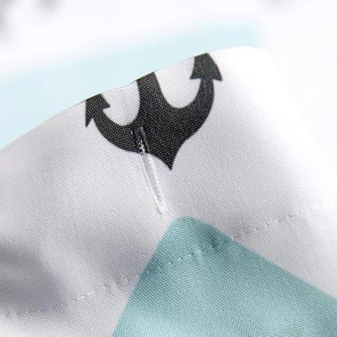 a close up of a white shirt with a black anchor on it