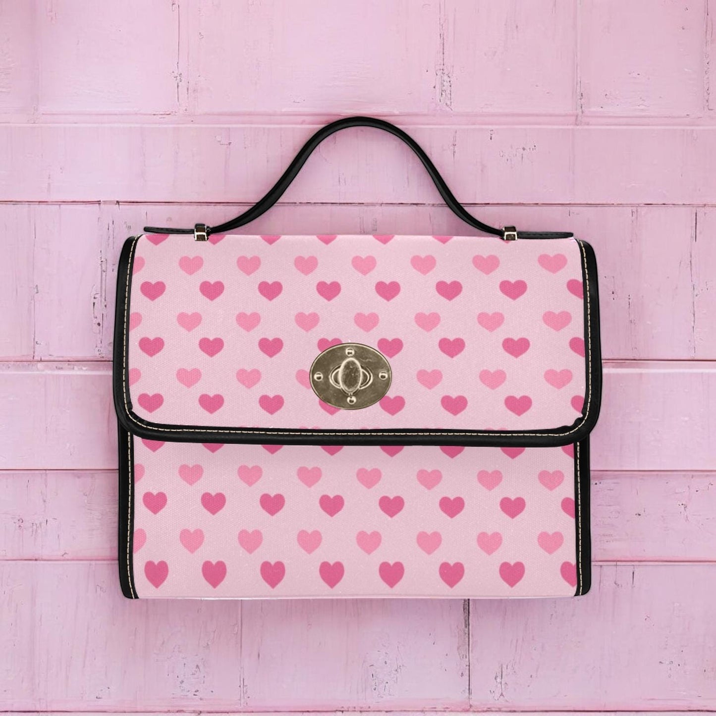 a pink and black purse with hearts on it