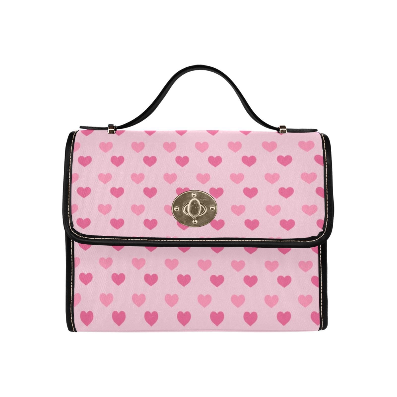 a pink and black purse with hearts on it